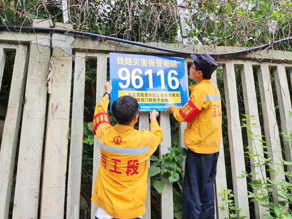 作业人员正在田东-田阳区间粘贴警示电话