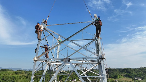 重庆合川电厂三期500千伏送出工程施工现场，作业人员组立首基铁塔。陈明月摄