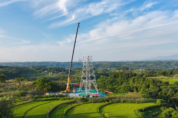 重庆合川电厂三期500千伏送出工程施工现场，作业人员组立首基铁塔。陈明月摄