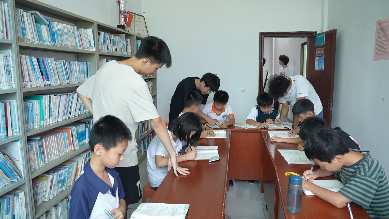 杜家村综合楼内，大学生志愿者正在辅导作业。